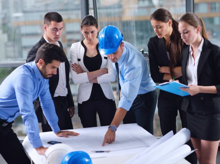 Engenheiros e trabalhadores de uma construtora analisando um projeto