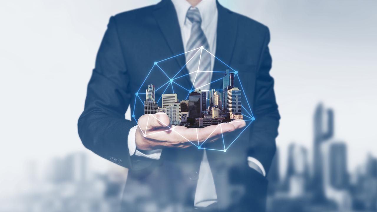 Homem com vários imóveis na palma de suas mãos, simbolizando uma incorporadora